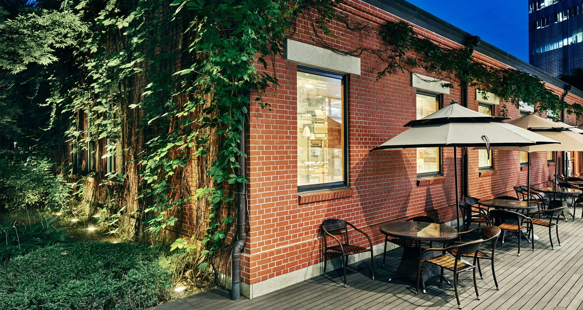 Official exterior of Coffee Libre Times Square in a red-brick Kyungbang building with outdoor seating