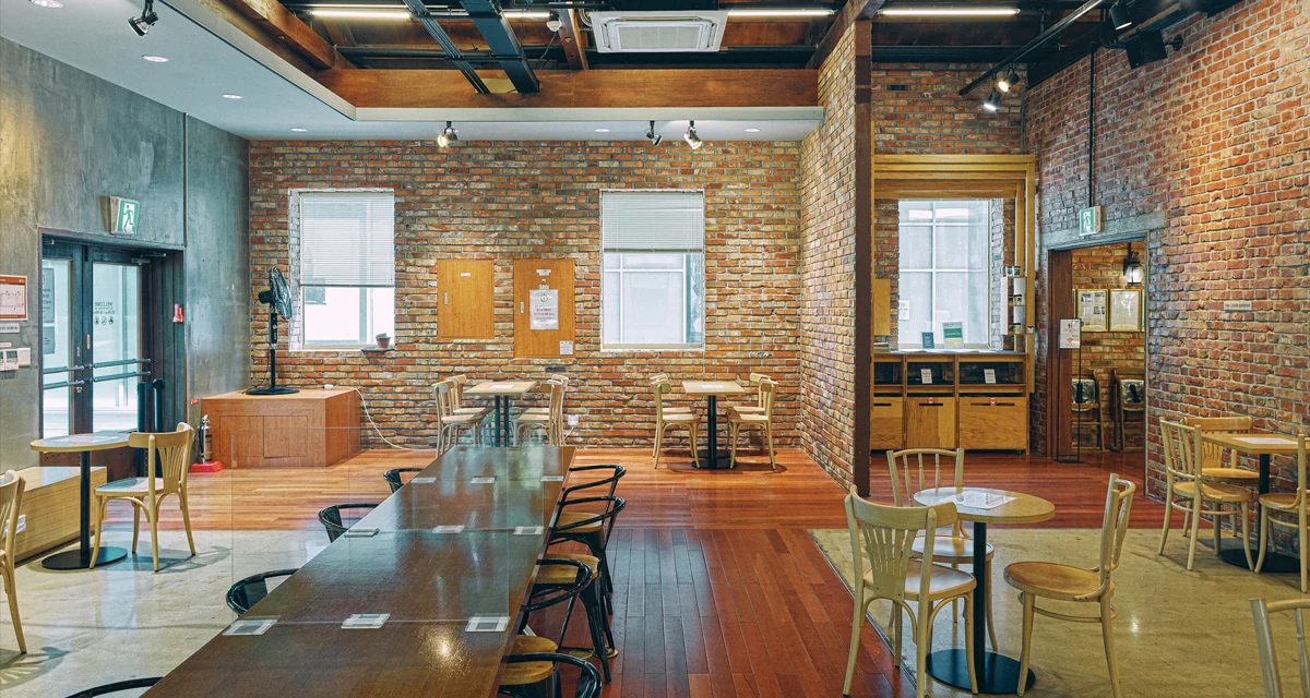 Official interior of Coffee Libre Times Square with brick walls and communal tables