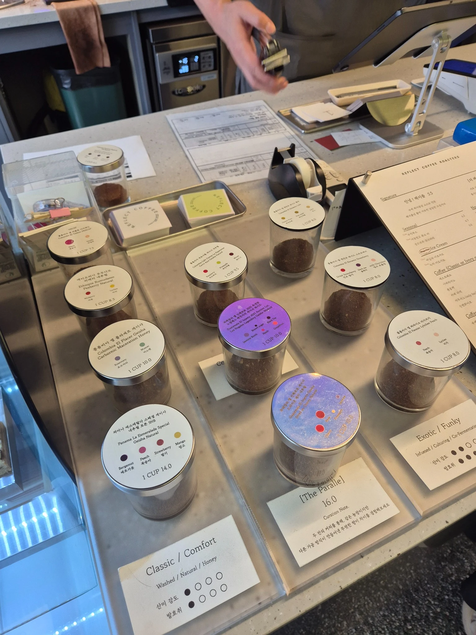 Reflect Coffee bean sample jars with flavor labels at the counter
